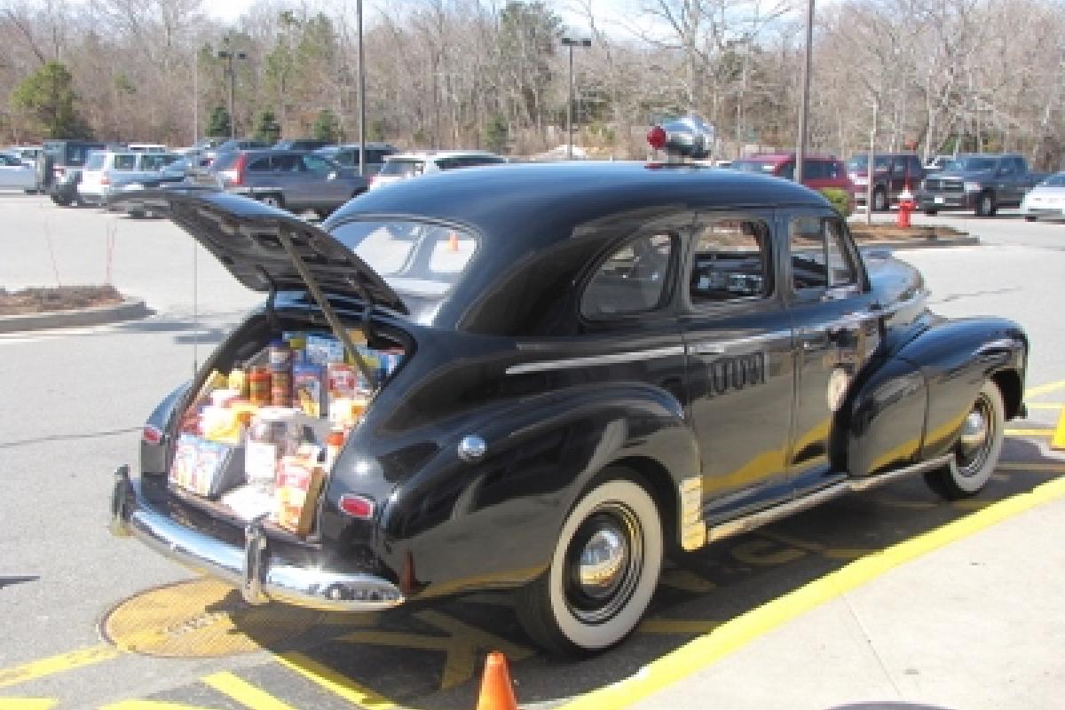 An antique police car full of donated food